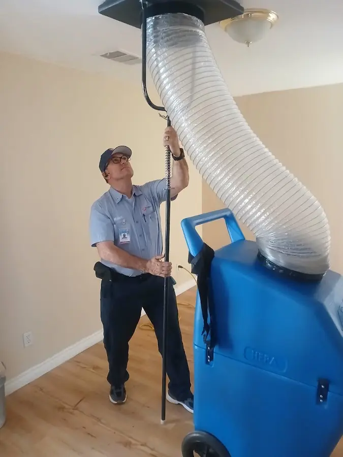 Furnace Tune-Up technician using HEPA equipment in Harvest
